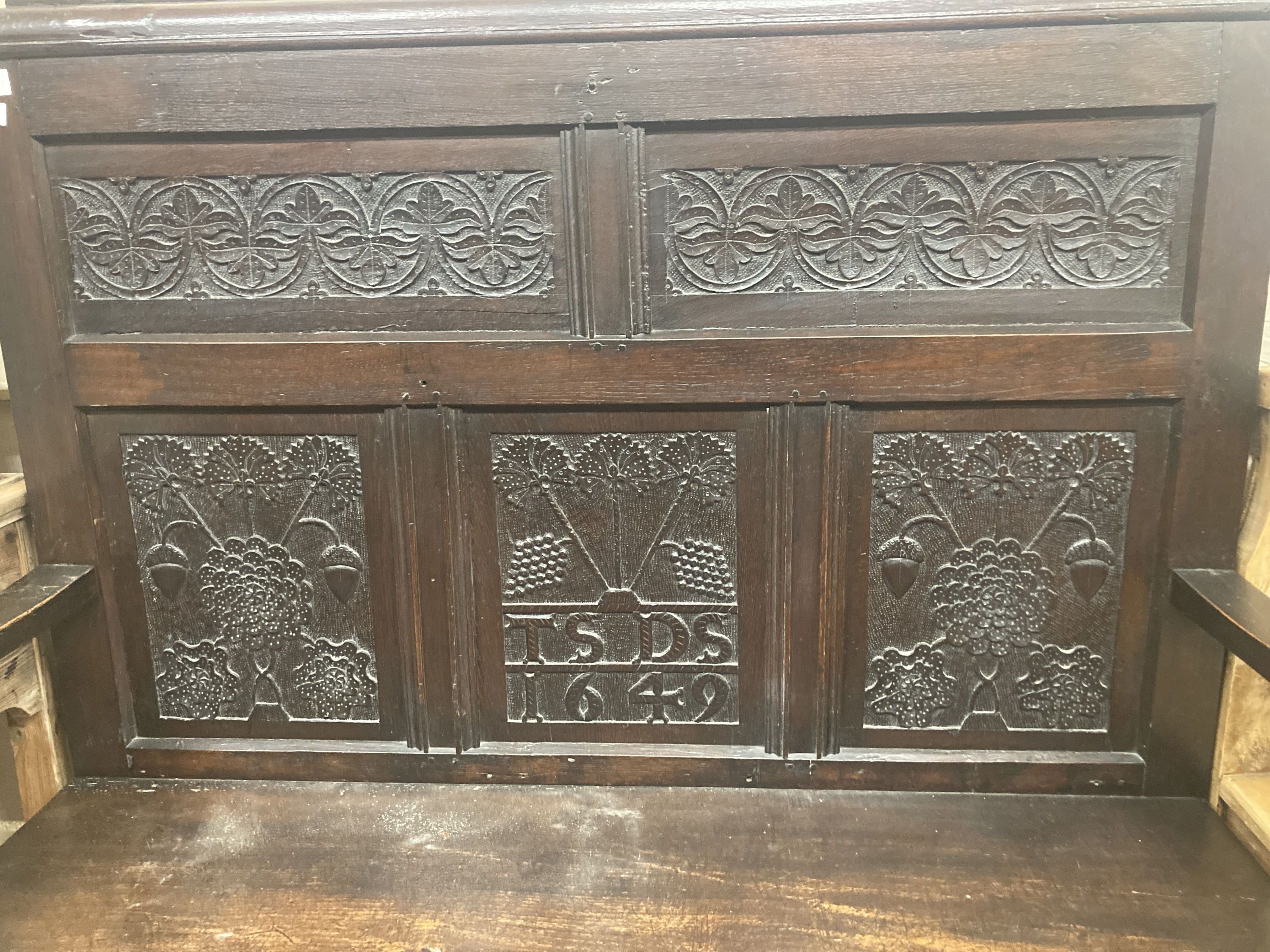 A 19th century oak settle incorporating 17th century panels, width 137cm, depth 44cm, height 131cm